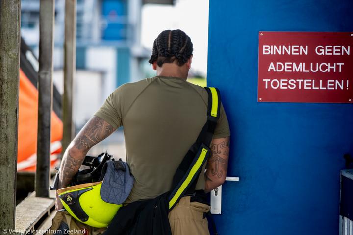Brandweerman bij het bord: binnen geen ademlucht