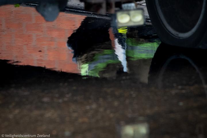 Reflectie van een brandweerman in het water